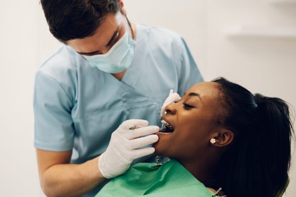 dentist-providing-dental-care-treatment-to-a-african-american-female-patient.jpg
